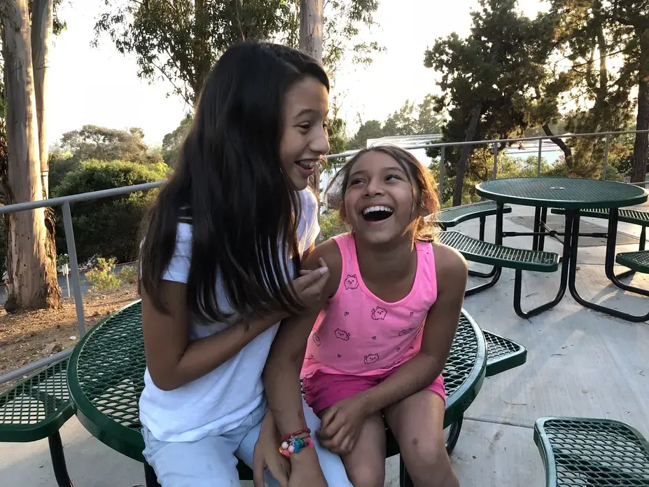 Adrianna and Cassandra share a laugh at Holy Names University. Located in the Oakland Hills, it’s Camp Suzanne’s home base. Image by Jaime Joyce for Time EDGE. California, 2018.
