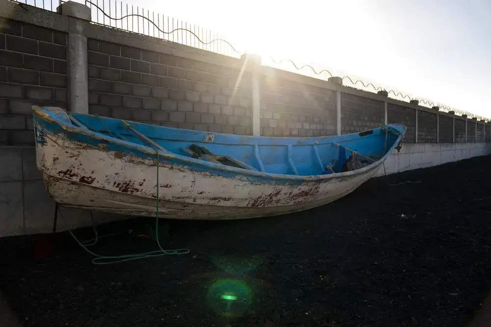 A wooden boat carrying the remains of migrant belongings is seen at the Arinaga port in Gran Canaria island, on Wednesday, Aug. 19, 2020. Image by Emilio Morenatti/AP Photo. Spain, 2020.