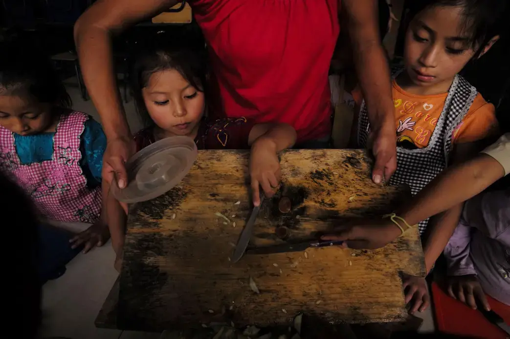 At Paso a Paso School in San Antonio Aguas Calientes, the kids make lunch with a stove made by the Ecocomal company, whose co-founder, Ana Luisa Herrera, also started the school. Safe, smokeless cook stoves promote education—because they help protect children’s health. Image by Lynn Johnson. Guatemala, 2017.