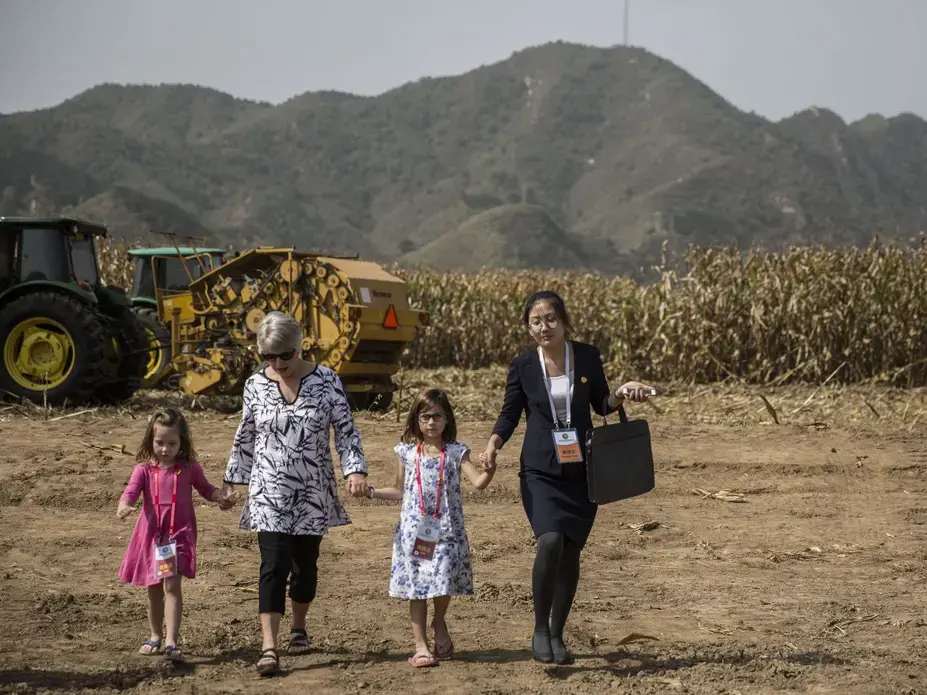 Chris Branstad, hand-in-hand with her granddaughters, Stella and Sofia Costa, leave a groundbreaking ceremony for the China-U.S. Demonstration Farm on Saturday, Sept. 23, 2017, in Luanping County, Hebei, China. Image by Kelsey Kremer. China, 2017.