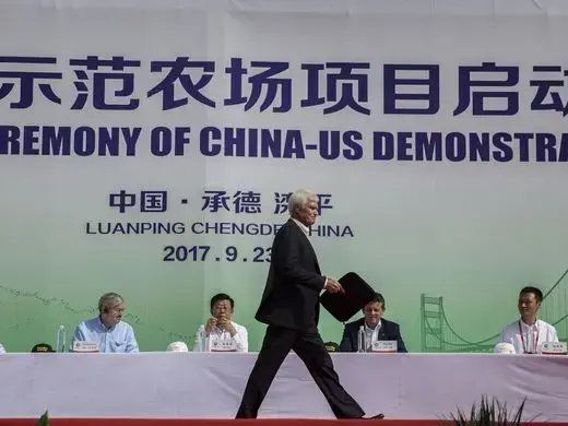Rick Kimberley, a farmer from Maxwell, Iowa, walks across the stage to speak during the groundbreaking of the China-US Demonstration Farm Luanping County, Hebei. The farm in China will be modeled after Kimberley's farm in Iowa. Image by Kelsey Kremer. China, 2017.