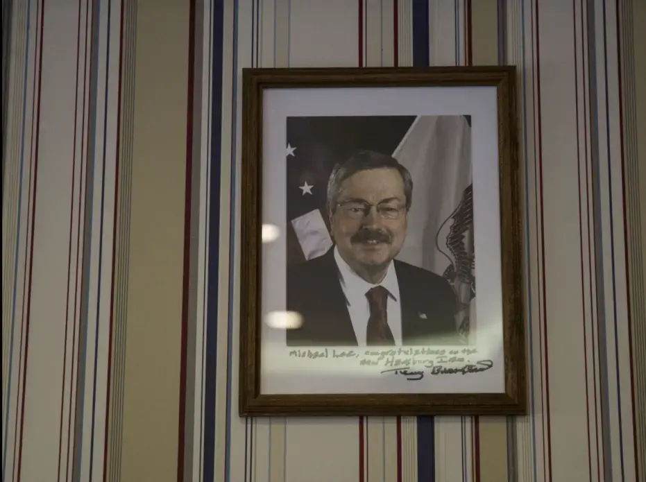 A photo of Terry Branstad, former governor of Iowa and current U.S. ambassador to China, hangs on the wall of the Hamburg Inn No. 2 on Rochester Avenue in Iowa City on Friday, Oct. 6, 2017. The note reads, 'Michael Lee, Congratulations on the new Hamburg Inn.' Image by Kelsey Kremer. United States, 2017.