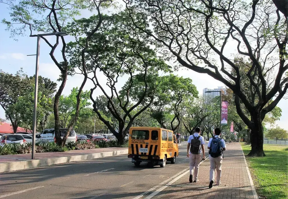 Ateneo’s solution: Build and maintain a network of wide sidewalks. Take care of old trees so that their canopy can shield the people who walk from the elements. Image by  Dinna Louise C. Dayao. Philippines, 2017. 