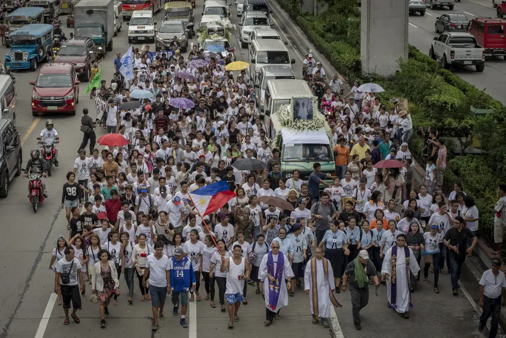 Relatives, friends, and church leaders walk through the funeral procession of Kian Loyd Delos Santos along EDSA Highway in Caloocan, Metro Manila. Image by Eloisa Lopez. Philippines, 2017. 