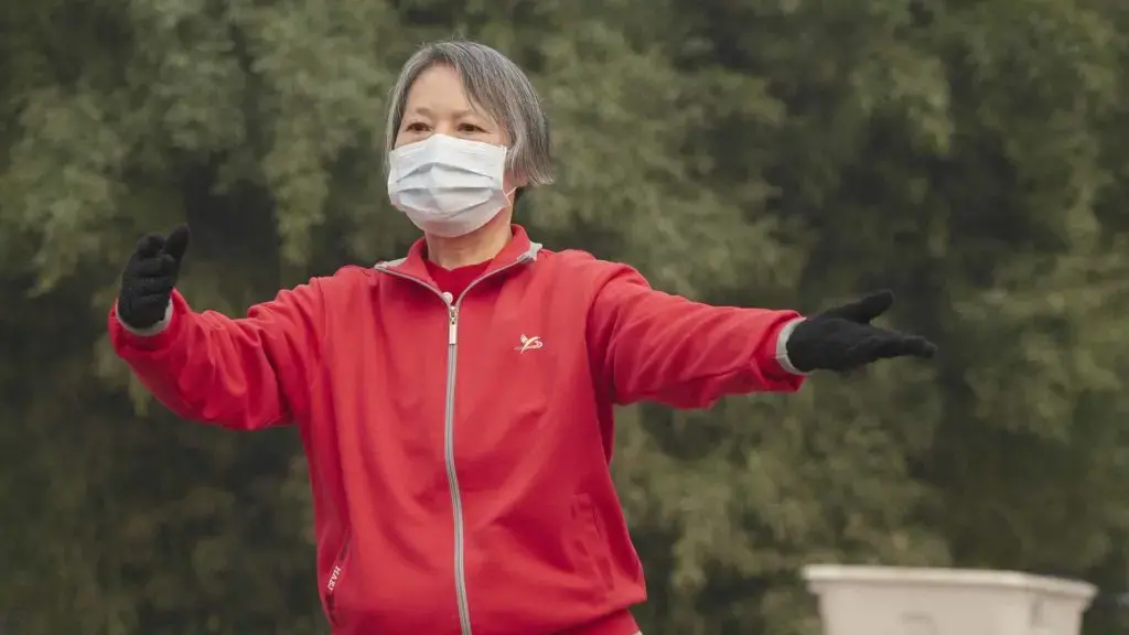 A woman goes through her morning Tai Chi routine in Shijiazhuang’s Ping An Park — exercising her body while trying to protect her lungs. Image by Larry C. Price. China, 2018.