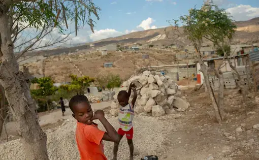 Boys play near their homes along a ridge overlooking the sea in the Village du Pecheur neighborhood of greater Canaan, Haiti. Image by Allison Shelley. Haiti, 2019.