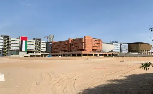 View from the road of Masdar City’s completed buildings. From left to right: Siemens Middle East Headquarters, Khalifa University Residential Building, Knowledge Centre, Multipurpose Khalifa University Building, and Multi-Use Hall. Image by Anna Gleason. United Arab Emirates, 2019.