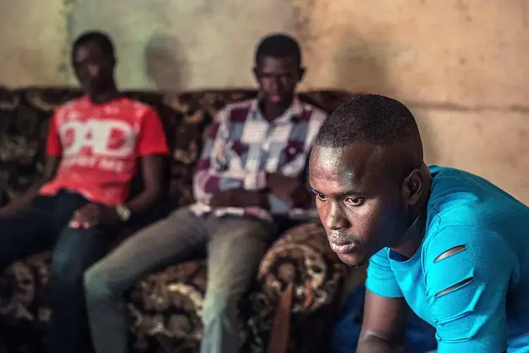 Traoré watches television with a group of young men in his uncle’s living room in Bamako. Image by Nichole Sobecki. Mali, 2017. 