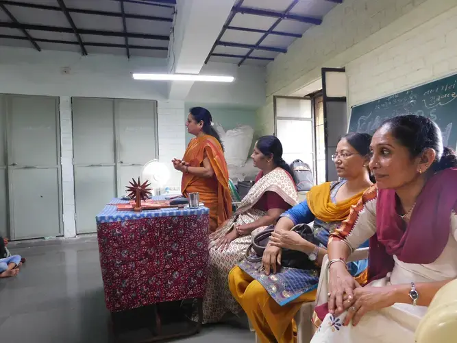 Health officials speak on women’s health and swine flu prevention at the Breastfeeding Clinic at the Manav Sadhna Women’s Center. From left to right: Zala Chandrikaben (in green, obscured by speaker), Nandini Pandya, Subiya Paromadoben, Dr. Belaben Patel, Harshaben Darji. Image by Ambar Castillo. India, 2017.