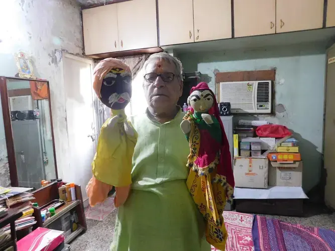 Health trainer Kirit Shelat prepares to tell a toilet love story via two of his favorite puppets. Image by Ambar Castillo. India, 2017.