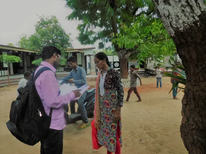 Health coordinator Ajay Vaghela and health worker Modi Niven compare notes at one of the local Manav Sadhna schools. Image by Ambar Castillo. India, 2017.