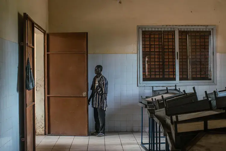 Siaka Koné, the lone security guard at the Kolondiéba plant, makes his rounds of the deserted buildings in July. Image by Nichole Sobecki. Mali, 2017.