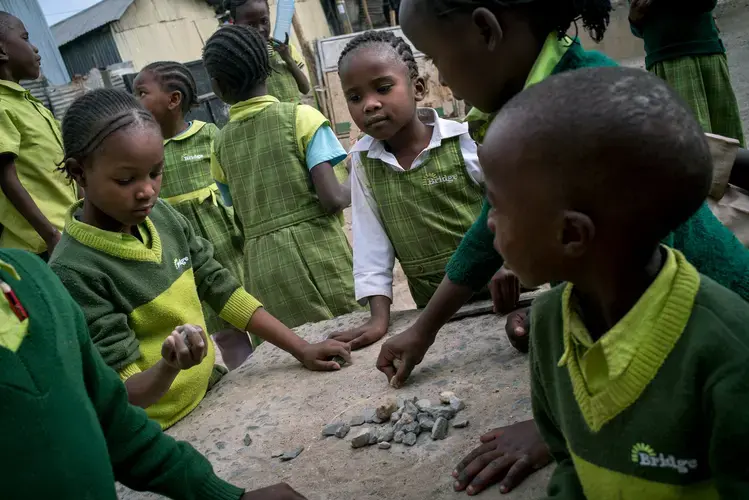 Students play with rocks outside Bridge Diamond in the Mukuru slum in Nairobi. Image by Diana Zeyneb Alhindawi for The New York Times. Kenya, 2017.<br />
