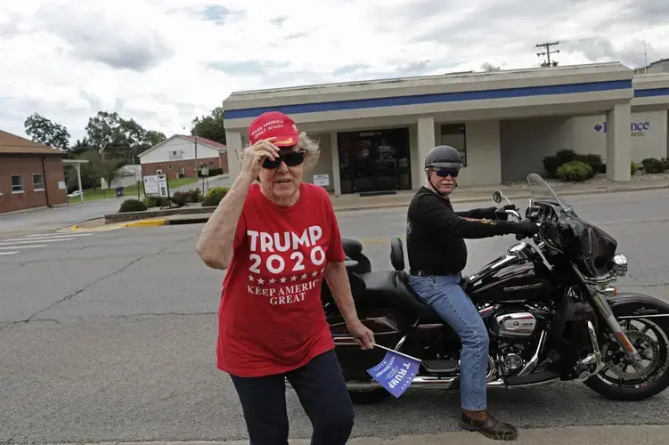 Doris Miller 86, left, adjusts her cap after getting off the back of a motorcycle belonging to Jeff Bundren, 60, Sunday, Aug. 2, 2020, in Vienna, Ill. This is a deeply conservative part of the nation. 77 percent of the county voted for President Donald Trump in the 2016 elections; just 19 percent went for Hillary Clinton. Image by Wong Maye-E/AP Photo. United States, 2020.