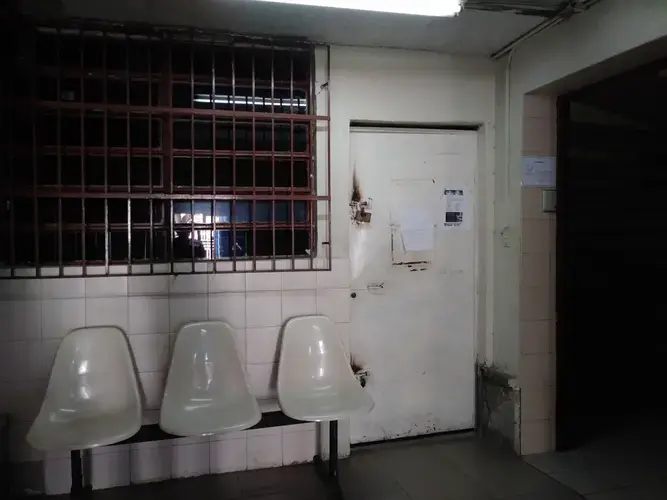 The waiting room at Clinica Riverside, in East Caracas, where Carlos Román receives dialysis three times a week, is a dark room with dim white light and rusty white metal chairs. Family members and visitors are not allowed inside the dialysis unit and must wait outside until the patient's session is finished.