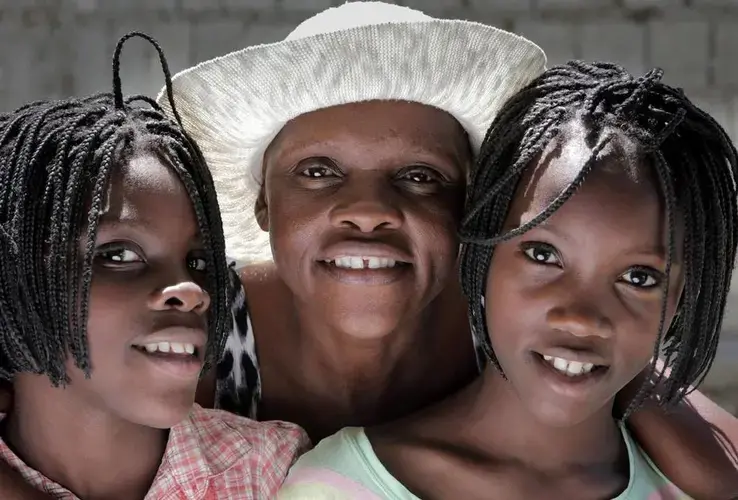 Guerda Janvier (center), who has advanced cervical cancer, wants more than anything to see her 11-year-old twin daughters, Brithney (left) and Briana Osselin (right), grow up.<br />
Image by José A. Iglesias. Haiti, 2018.
