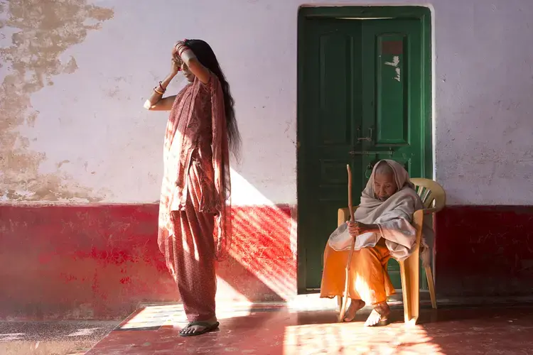 In a shelter in Vrindavan, known as a 'city of widows,' Lalita (at right) bears the cropped hair and white wrap of her culture once considered obligatory for widowhood. Shelter manager Ranjana, a much younger widow, is less constrained by traditional customs. Image by Amy Toensing. India, 2013.