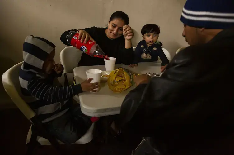 Aracely and Juan Carlos eat lunch with their three children at a shelter in Tijuana. Image by Erika Schultz. Mexico, 2019.