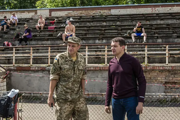 Vadym Svyrydenko (right) talks to colleague after the qualifying race for the 43rd Marine Corps Marathon, which he organized, in Kyiv. Image by Oksana Parafeniuk, courtesy of Roads & Kingdoms. Ukraine, 2018.