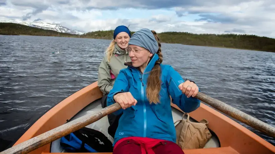 Mathilda Nyzell and Jenny Gåling, master's students at the Stockholm University, trade off rowing while they collect data from methane traps. Image by Amy Martin. Sweden, 2018.