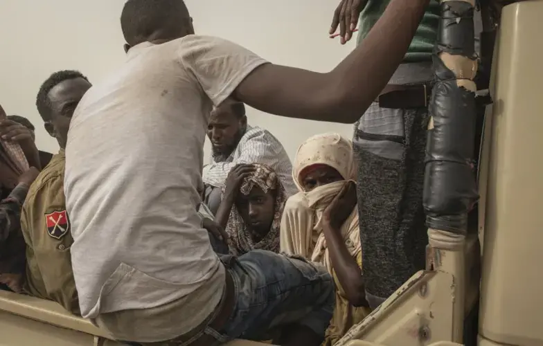 Ethiopian migrants sit in the back of a pickup truck to be taken to desert compounds known in Arabic as 'hosh.' Image by Nariman El-Mofty. Yemen, 2019.