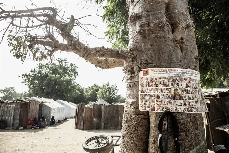 A sign at a refugee camp in northern Nigeria showing people wanted on suspicion of being Boko Haram members. Image by Glenna Gordon. Nigeria, 2017. 