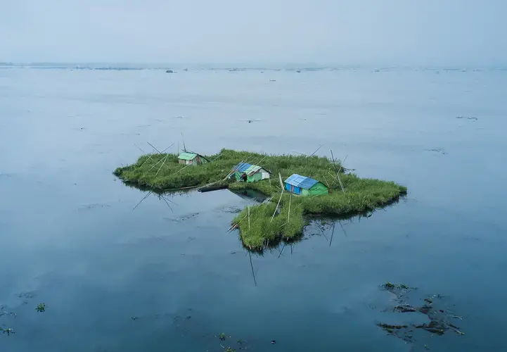 A view of Phum Shangs (floating huts) inside Loktak Lake, Manipur. The Loktak Development Authority (LDA) has dredged most Phumdis (floating biomass) and Phum Shangs in the name of lake cleanup. Image by Neeta Satam. India, 2017.