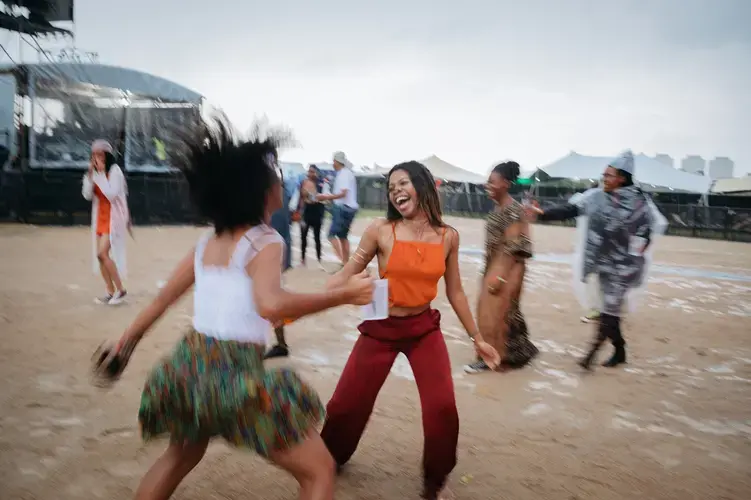 Rain can't dampen the spirits of Afropunk Joburg attendees. They continue to dance as rain begins to fall in Johannesburg in December. Image by Melissa Bunni Elian. South Africa, 2017.