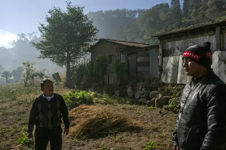 Elias López and his grandfather Julio stand in front of the property they have put up as bank collateral. Image by Mauricio Lima. Guatemala, 2019. </p>
<p>