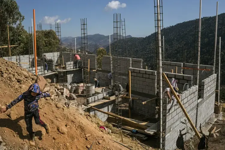 A construction crew works on a five-bedroom house for a migrant living in the United States. Image by Mauricio Lima. Guatemala, 2019.