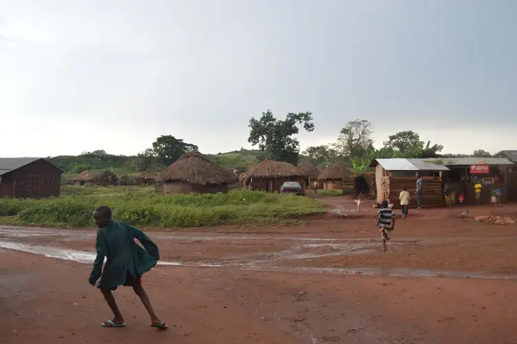 Children running across the road in Bukaleba village, which is isolated in the center of the forest. Image by Annika McGinnis. Uganda, 2019. 
