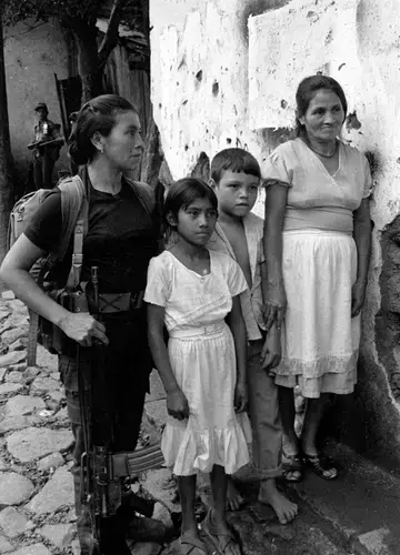 ERP combatant with civilians in Perquín. Image courtesy Linda Hess Miller. El Salvador, 1990.