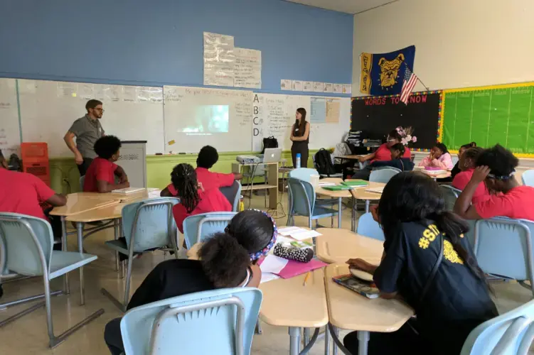 Dominic Bracco and Education Coordinator Hannah Berk speak with students at Center City PCS Capitol Hill about their narrative scripts. Image by Devani Lemmon. United States, 2019.<br /> 
