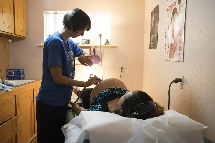 Vanna Waldron (left) evaluates Erika Piñon at the Holy Family Birthing Center in Weslaco, Texas. Waldron is a Certified Nurse Midwife from Seattle, Washington, who is volunteering at the birthing center for a year. Image by Reynaldo Leal for The Texas Tribune. ​​​​​​​United States, 2018. 