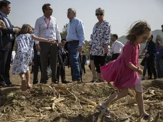 Ambassador Terry Branstad's granddaughters Stella, in the foreground, and Sofia Costa play at the edge of a corn field during the groundbreaking ceremony for the China-US Demonstration Farm on Saturday, Sept. 23, 2017, in Luanping County, Hebei, China. Image by Kelsey Kremer. China, 2017.