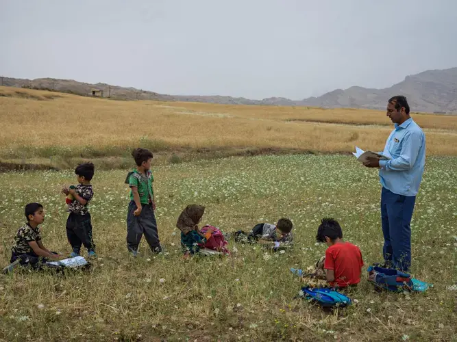 Ali Jahanbakhsh, 40, teaches a class in an open area of Khuzestan Province. Image by Newsha Tavakolian. Iran, 2018.