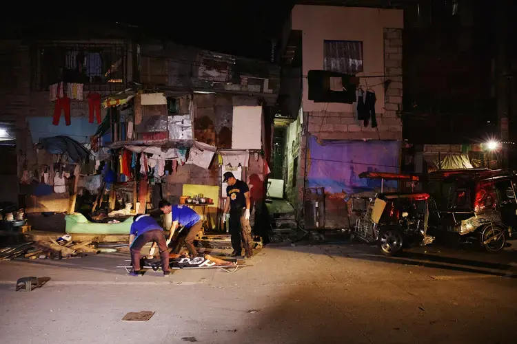 A crime scene on August 18th, 2017, in one of the slums of Manila, which has become known for frequent drug-related killings. On one particularly deadly night in August of 2017, 32 people were reportedly killed in a single night. “That’s good,” Duterte said in a speech shortly thereafter, “Let’s kill another 32 every day. Maybe we can reduce what ails this country.” Image by Pat Nabong. Philippines, 2017.