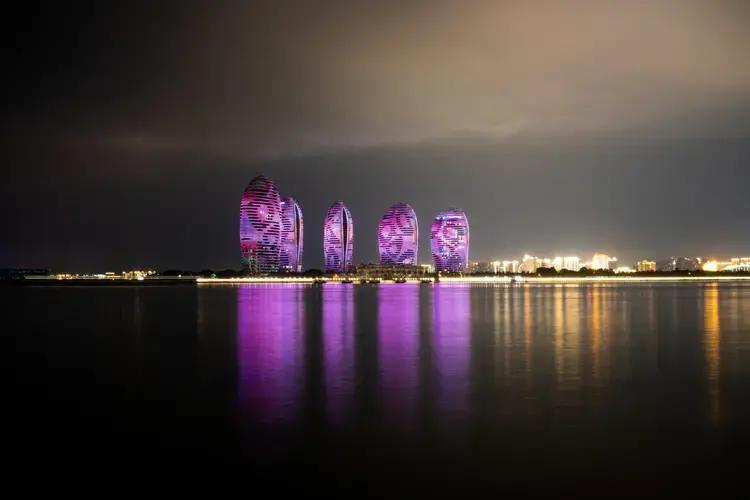 A view from on Phoenix island, Sanya, Hainan. Phoenix Island, on the resort city of Sanya, was the Hainan island’s first flagship land reclamation mega project, attracting internationally renowned architects. Reclaimed between 2002 and 2003, and opened for business in 2015, the artificial island in Sanya Bay has luxury apartments, hotels and a cruise centre — all a short distance from the centre of the city. A second phase of reclamation was undertaken in 2014 — seen here as the empty, sandy plot — bringing the total size of the island to 0.84 square kilometers. But this was found to have led to the erosion of over 2km of Sanya Bay’s coast. Following an environmental inspection in late 2017, the government has slapped a suspension on further construction as the project was found to have impacted coastal erosion and the ecosystem, and caused sedimentation at the mouth of the Sanya River. Companies involved in this project include New York-based Balmori Associates, which does landscape and urban design, and the brand-name Chinese architect Ma Yansong's firm MAD. Image by Sim Chi Yin. China, 2018. 