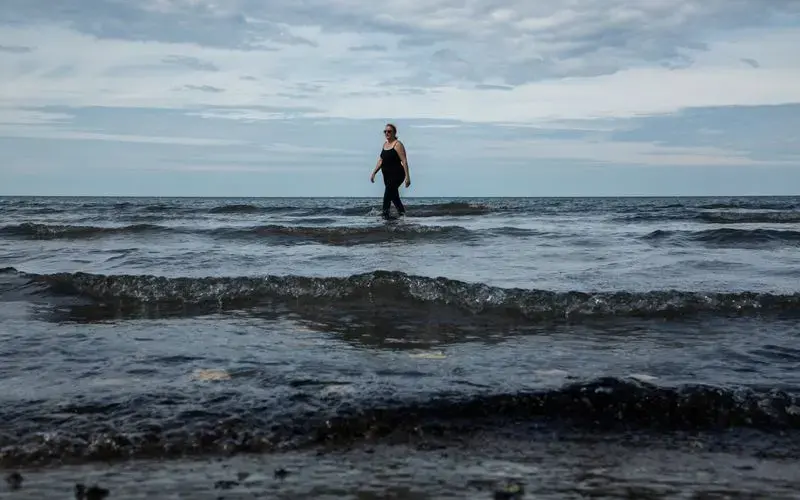 Therese Kastelic enjoys Edgewater Park Beach in Cleveland on Sept. 25, 2019. Lake Erie’s dead zone, which can span an area the size of Connecticut, lies mostly in deep, offshore waters. Image by Zbigniew Bzdak. United States, 2019.