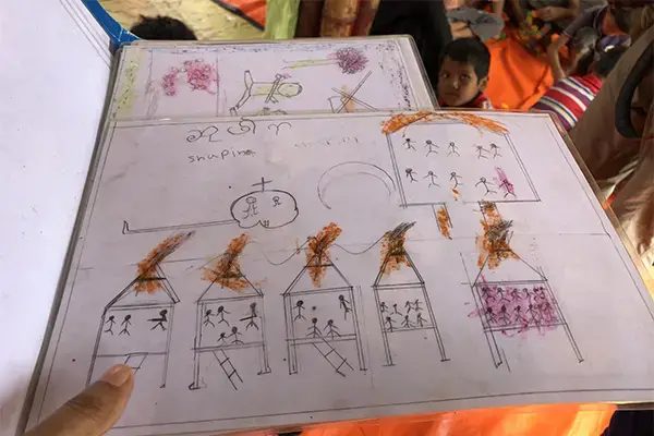 Certain images were common in drawings made by Rohingya refugee children arriving in Bangladesh a year ago: military helicopters, soldiers, homes on fire, and boats filled with stick-figure people. These are the children’s memories of attacks on their villages and of their escape. Image by Jaime Joyce, Bangladesh, 2018.<br />
