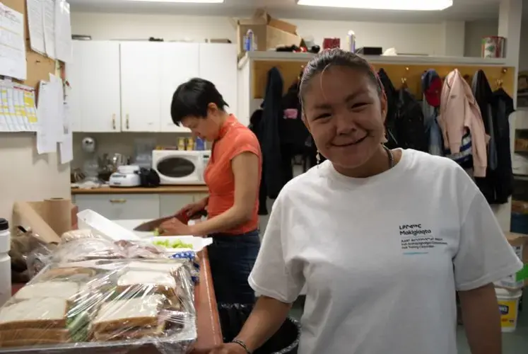 At Qajuqturvik Food Centre in Iqaluit, Marilyn Aupaloosie helps prepare meals for local residents. 'It’s my motivation,' she says of her work. 'I like to see the smiling faces.' Image by Julie De Meulemeester. Canada, 2018.<br />
