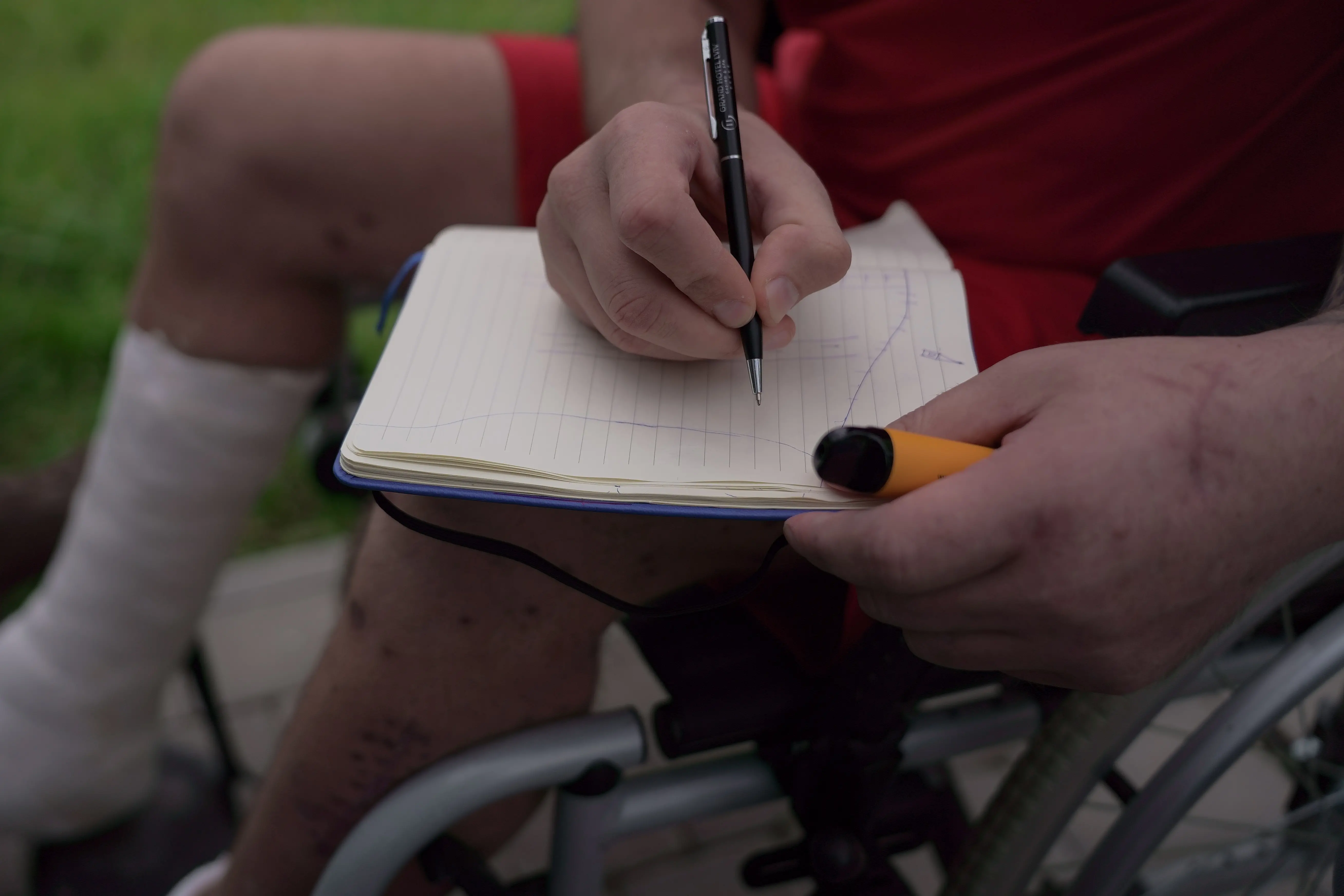 a man drawing a notebook in a wheelchair