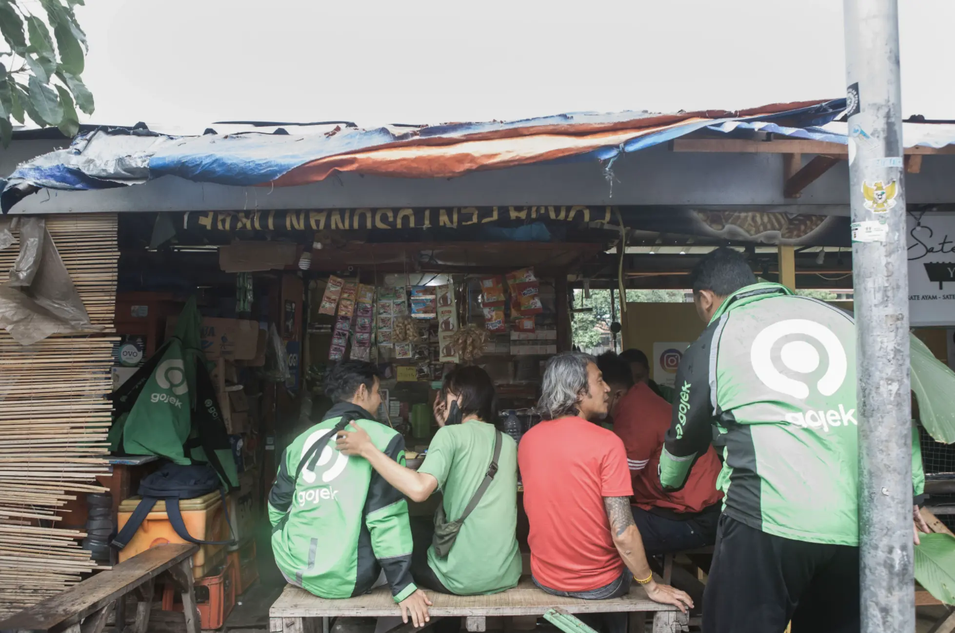 Delivery men in Indonesia sit at a stall