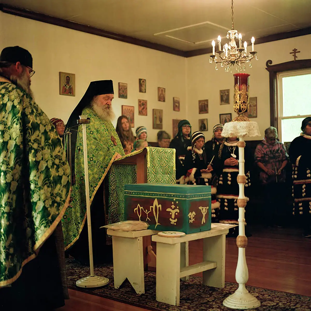 Priests in heavily patterned green and gold robing read from an altar before a decorated box of Anastasia's remains.