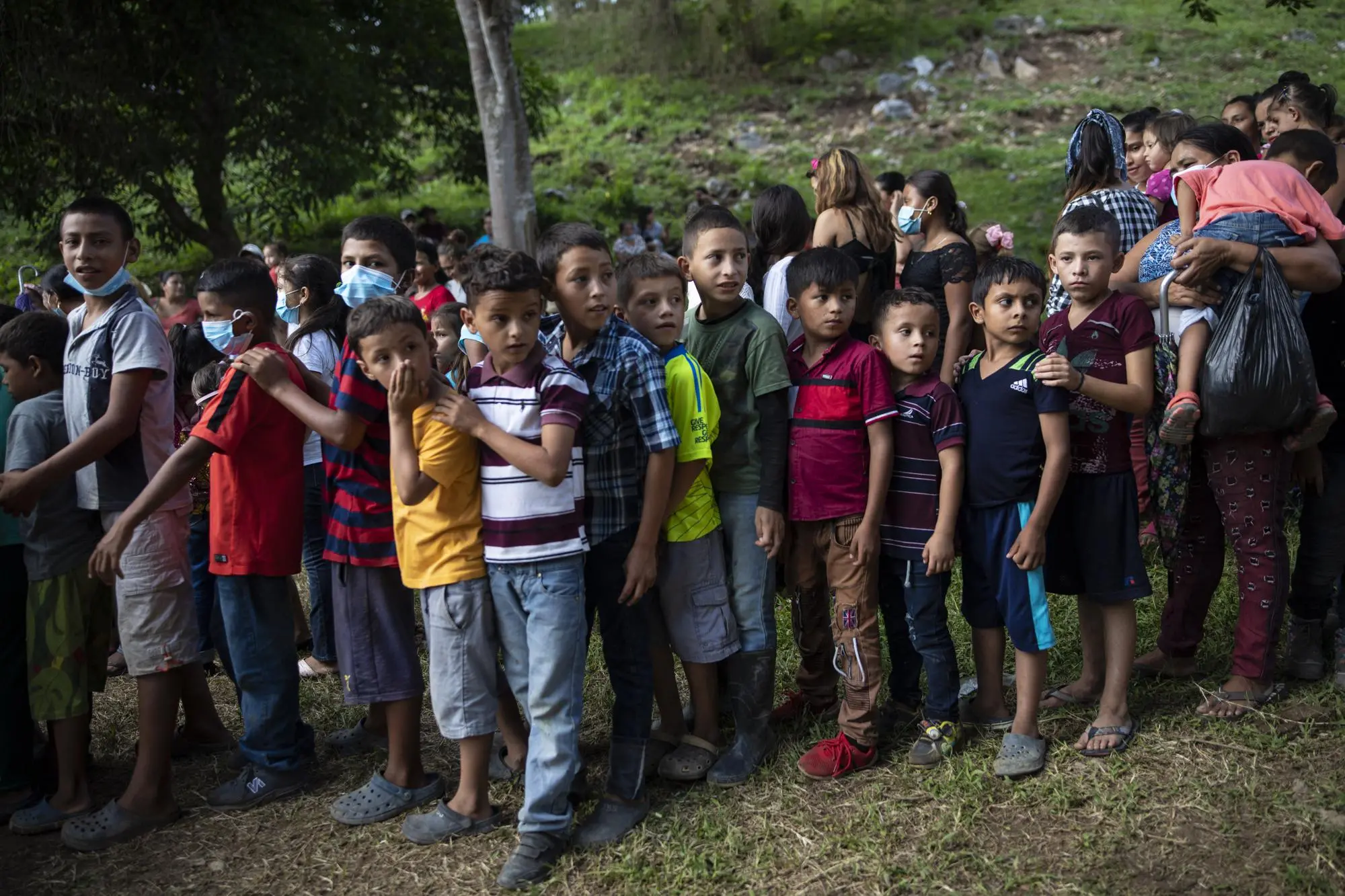 Children wait in line for toys from government officials