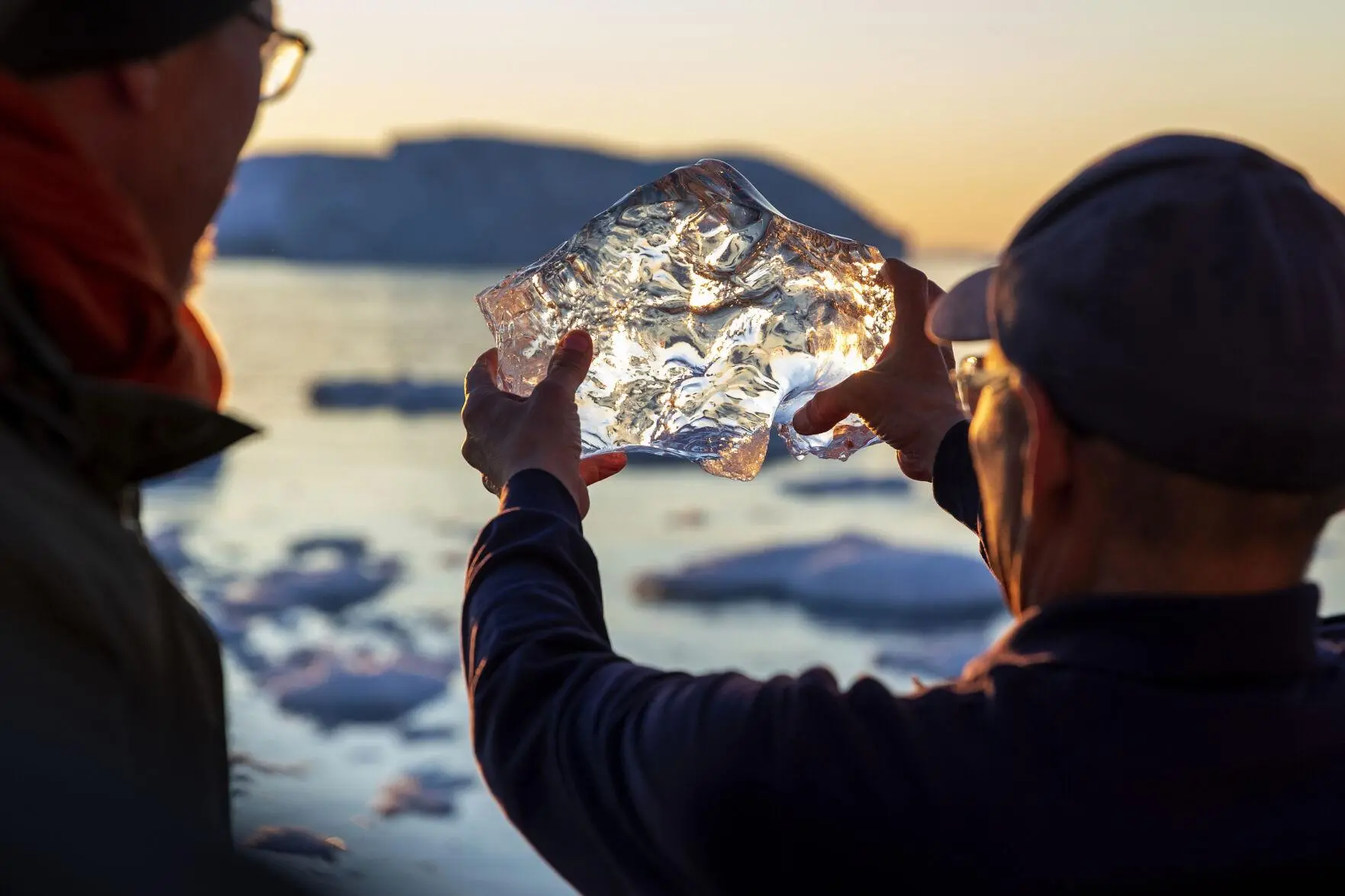 A tour guide holds up a piece of melting ice