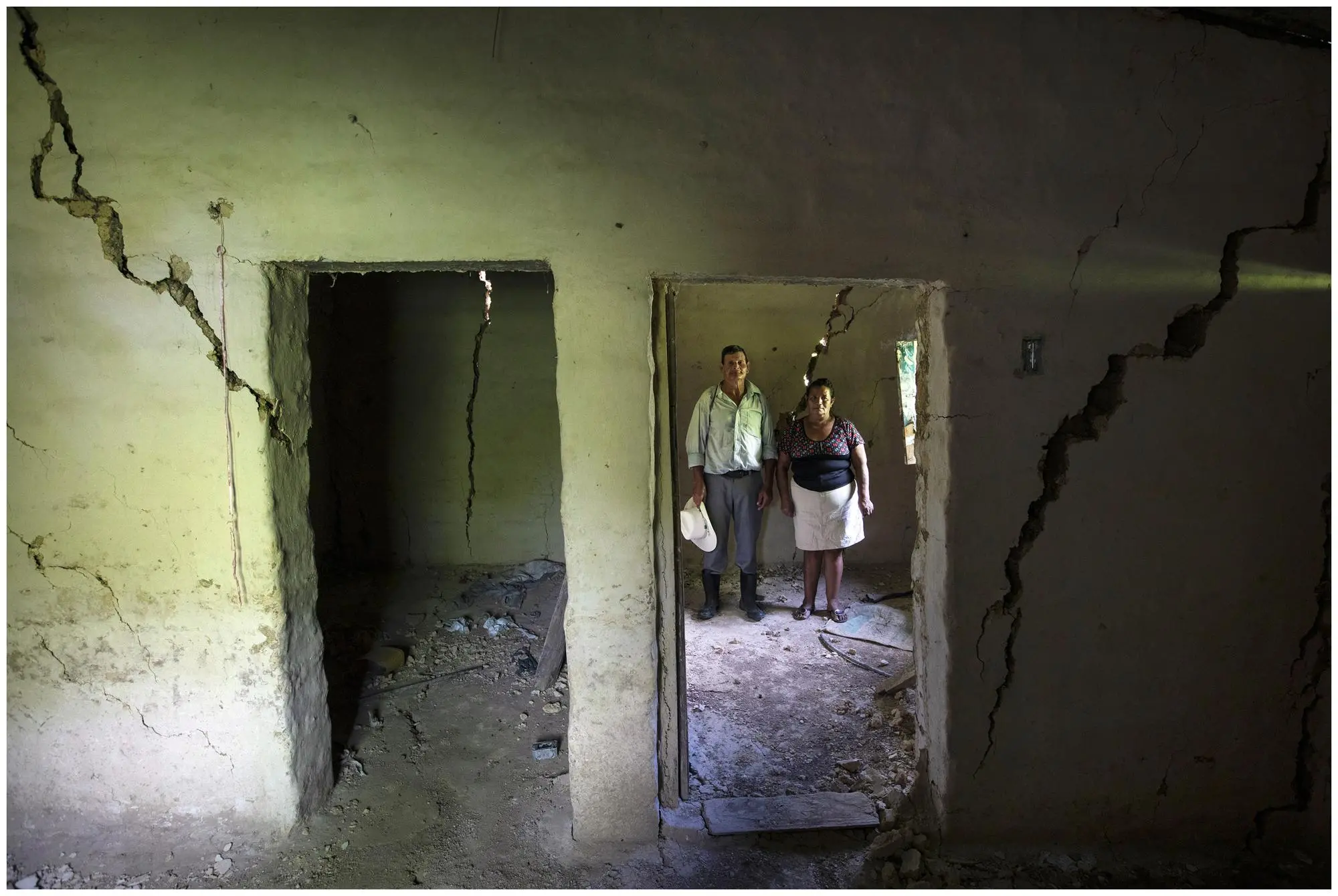 A couple stands in what remains of their house