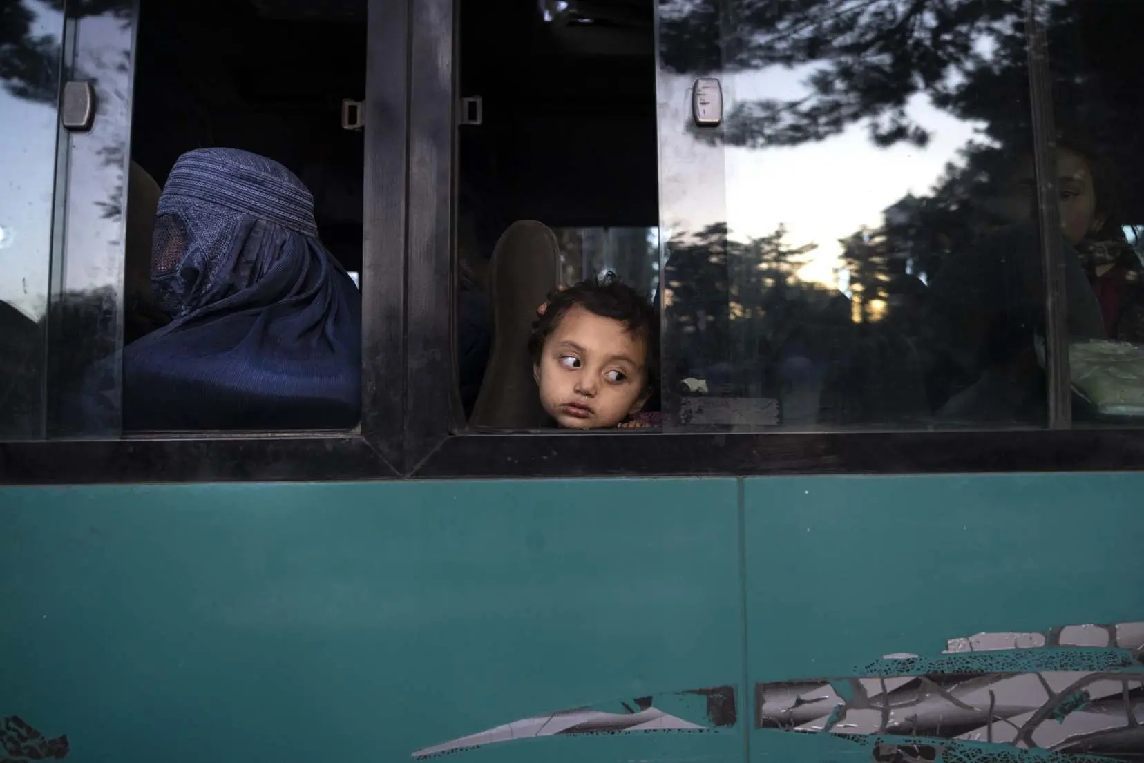 young girl looks outside a bus window