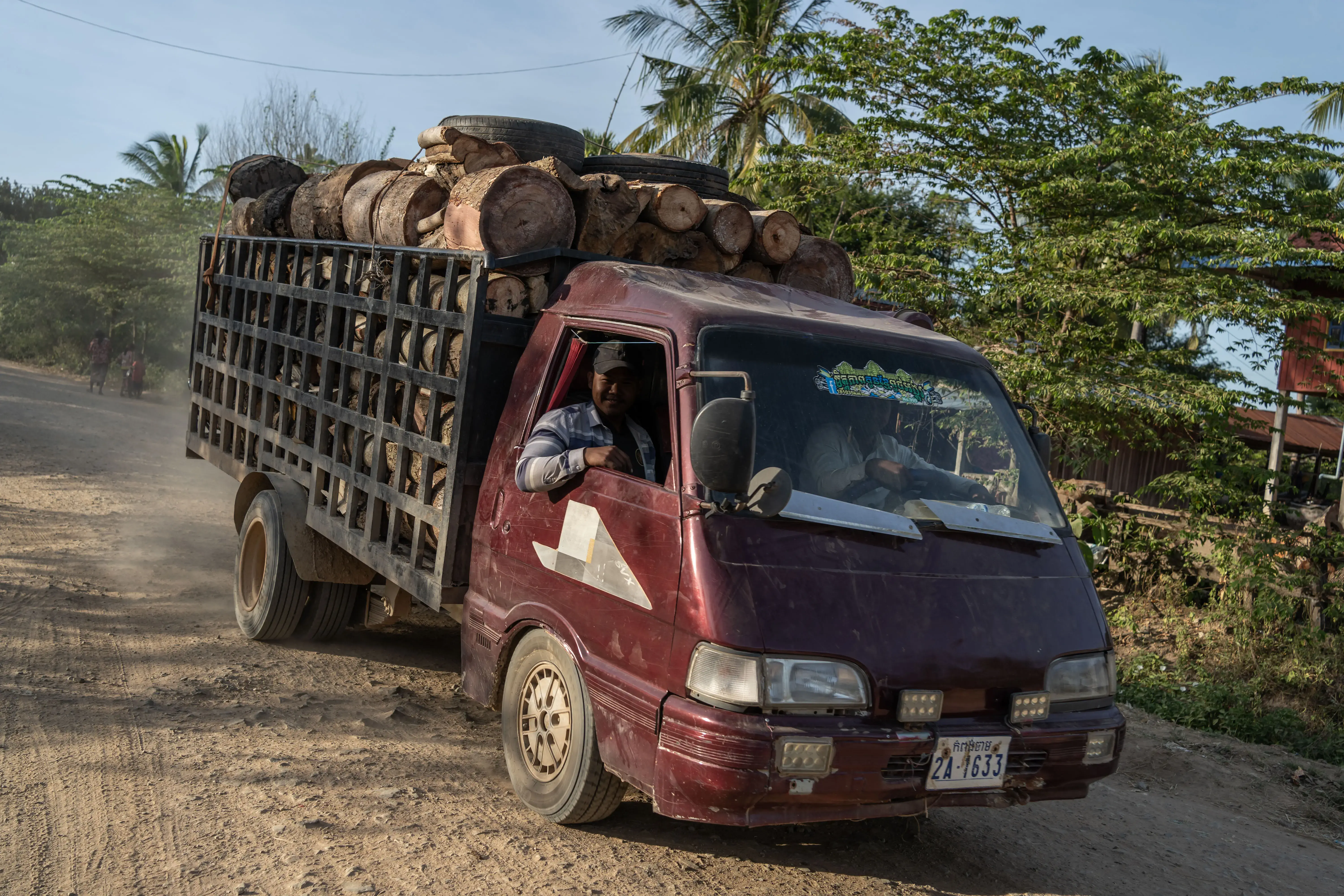 A middleman transports logs from the Aural Wildlife Sanctuary towards Chbar Mon where they will be sold to garment factories that incinerate the wood to generate steam. Credit: Andy Ball/Mongabay.