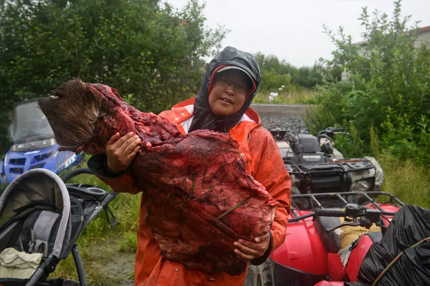 Photo of Emmonak resident holding up deer meat.
